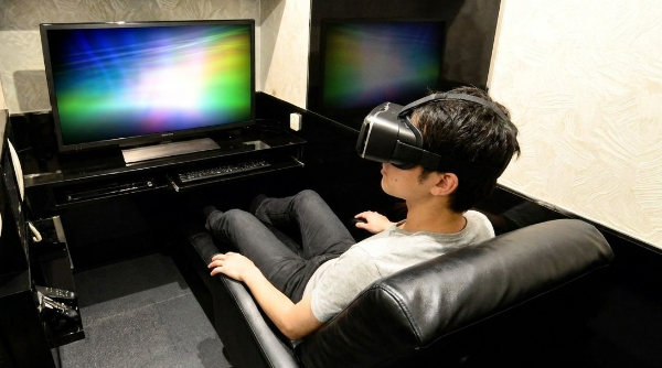 個室ビデオ店でVRを楽しんでいる男性